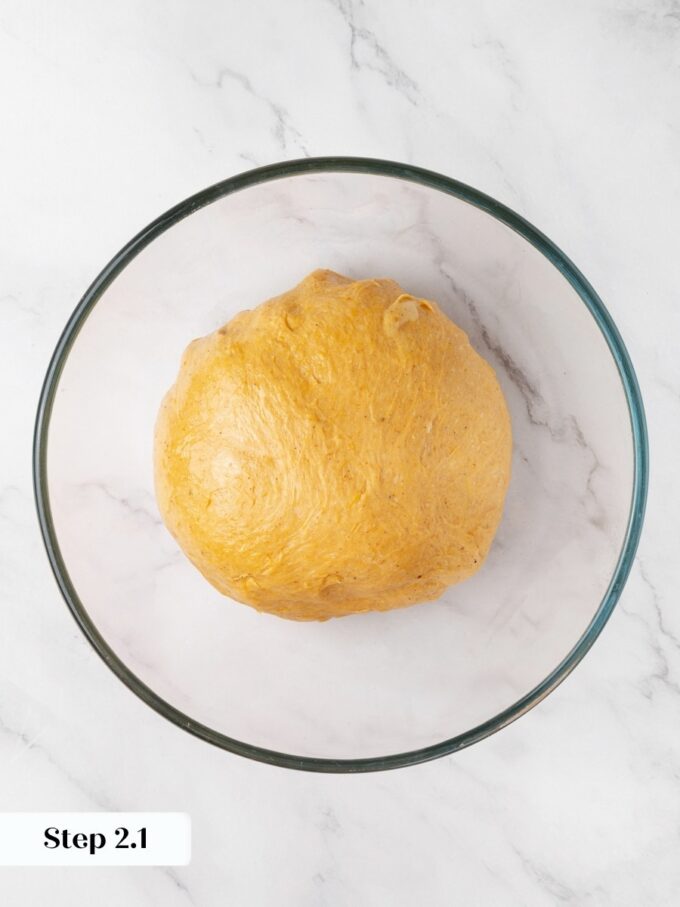 Shaping the dough into a tight ball helps pumpkin cinnamon rolls rise evenly in the bowl.